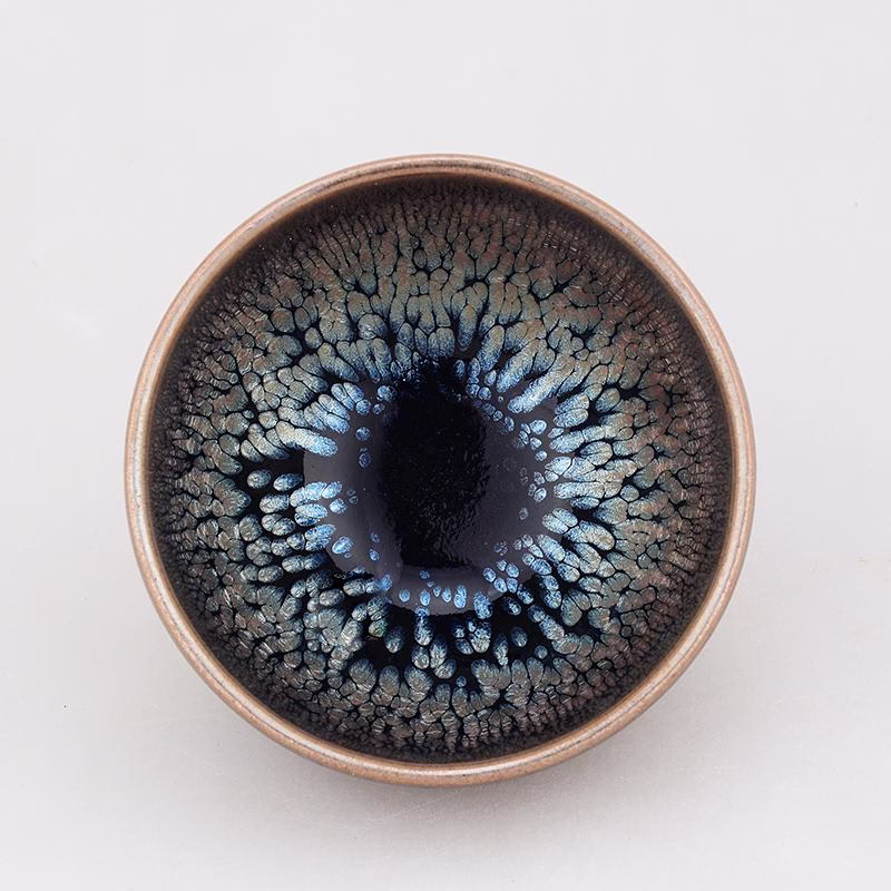 Dark-glazed Copperfield tea cup viewed from above, showing silver-blue spots and streaks across the bowl